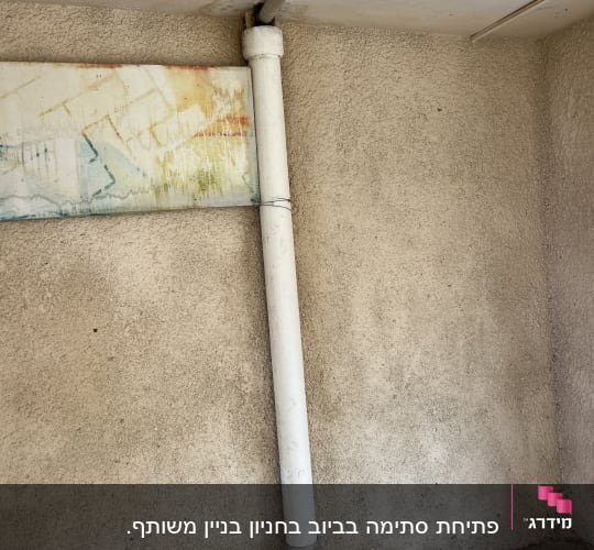 צינור לבן מחובר לתקרה וקיר, עם חיבורי מתכת